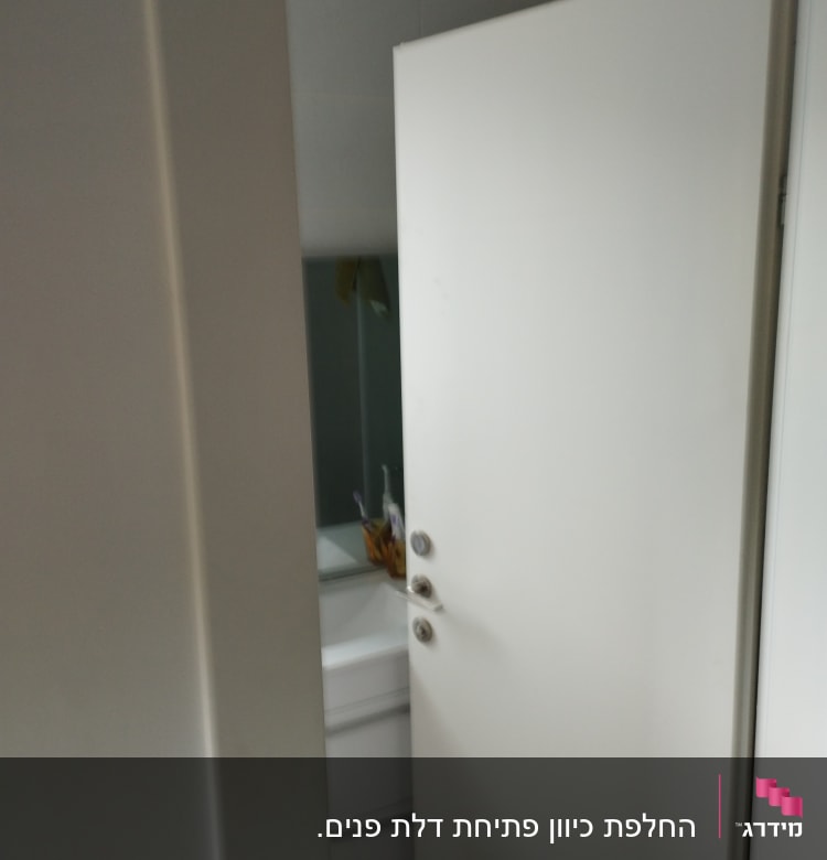 דלת לבנה פתוחה חלקית עם ידיות מתכת